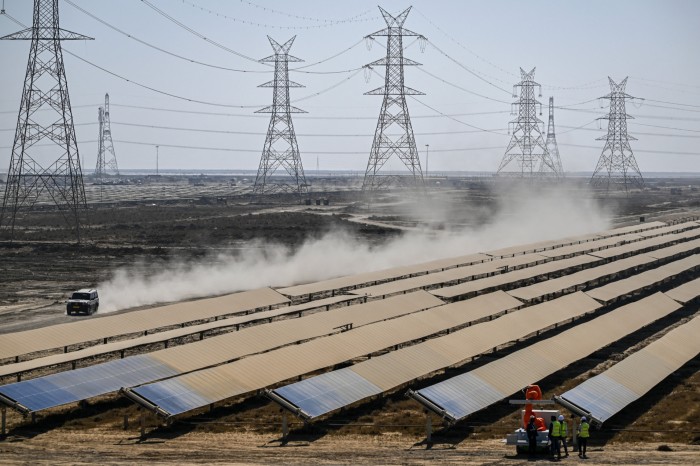 Workers install solar panels at Adani Group's renewable energy park in Khavda, India