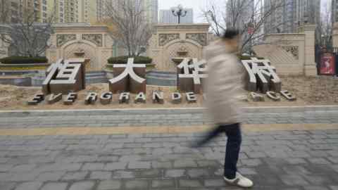 A man walks past the Evergrande Group residential complex called Evergrande Palace in Beijing