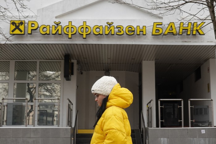 A woman walks in front of the Raiffeisen bank branch in Moscow