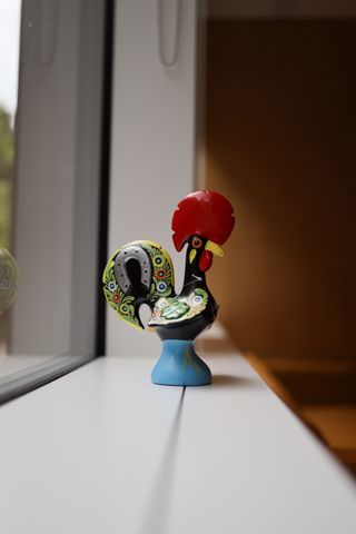 Figurine of a rooster sitting on a windowsill