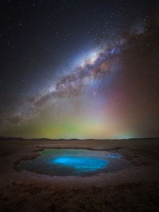 The Milky Way photographed above a bright blue pool in the Atacama Desert in Chile