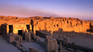 The sunrise begins to wake up the ruins of a small temple before the already illuminated larger remains of the Temple of Horus.