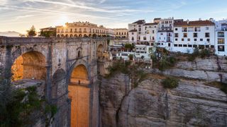 The bridge arch glowed in warm colors with white buildings in the distance.