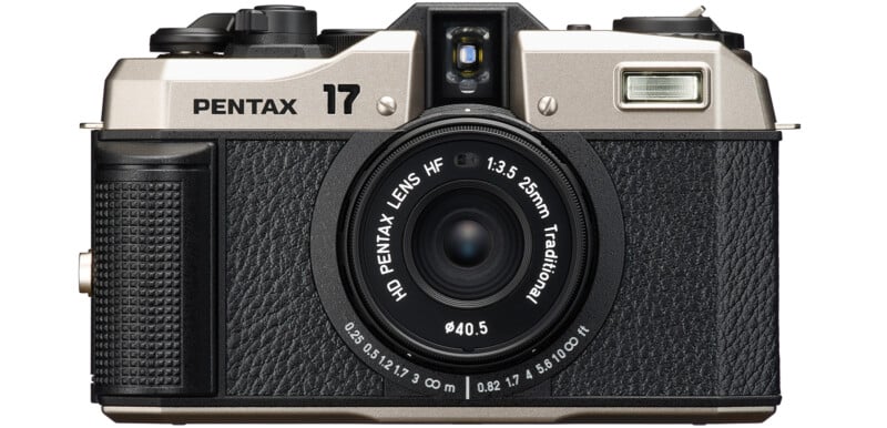 Front view of a Pentax camera with a 25mm f/3.5 lens.  The camera has a silver top, a black textured body and various control dials and buttons. "Pentax" and "17" are marked at the top along with the lens specifications around the lens barrel.