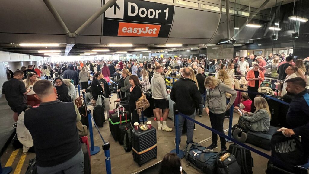 Passengers queue outside Terminal 1. Pic: Reuters