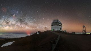 telescope on top of a mountain under a very starry sky