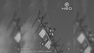 black and white image of the International Space Station showing solar panels and beams.  there are blurry copies on both sides of the image