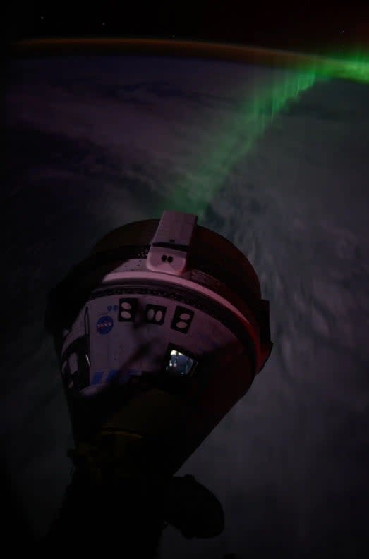 "Auroras stream below the Boeing Starliner spacecraft that docked with the forward port on the Harmony module as the International Space Station flew 266 miles over the Indian Ocean southwest of Australia," according to NASA.