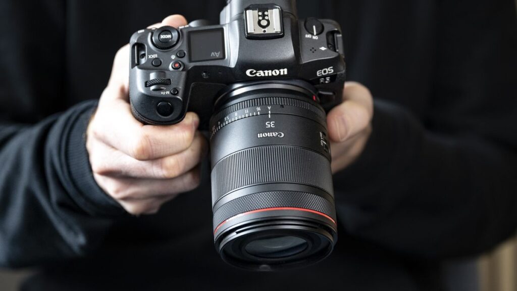 The Canon RF 35mm F1.4 lens attached to a Canon EOS R5, in the hand