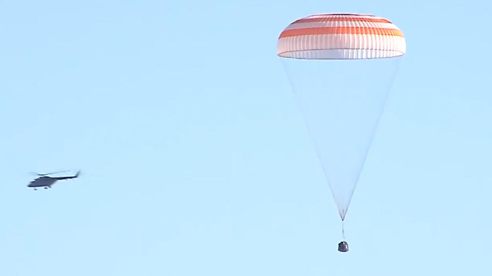 spaceship under parachute with helicopter