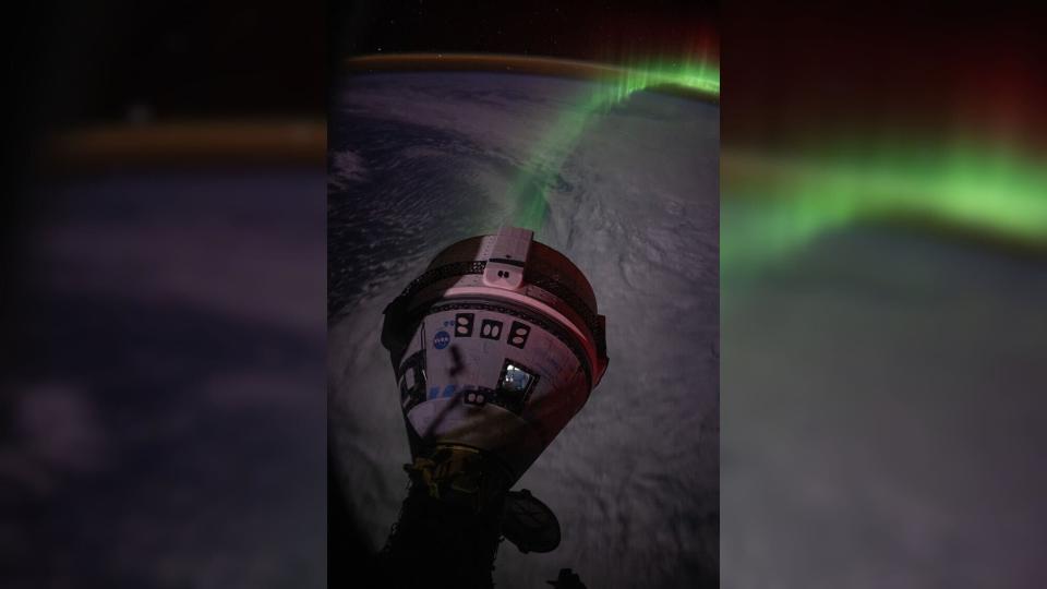 a spaceship in the shape of a cone in front of the green aurora above the earth, which is in shadow