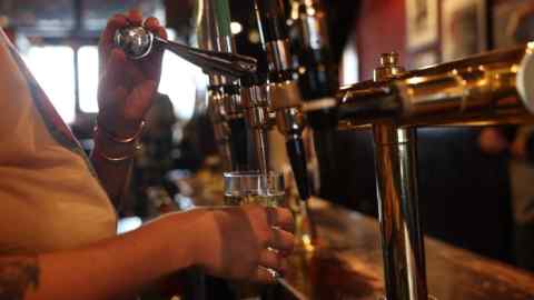 The bartender draws a pint