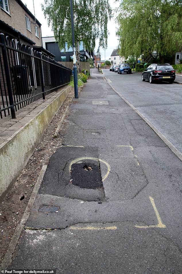 A pothole in the footpath opposite the cottage, which residents say the council should prioritize