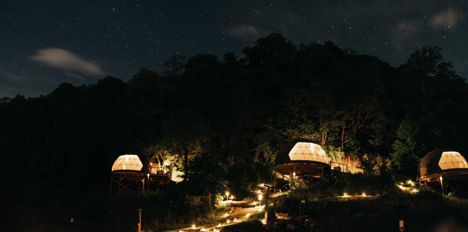 The Glamping Collective resort in North Carolina lit up at night.