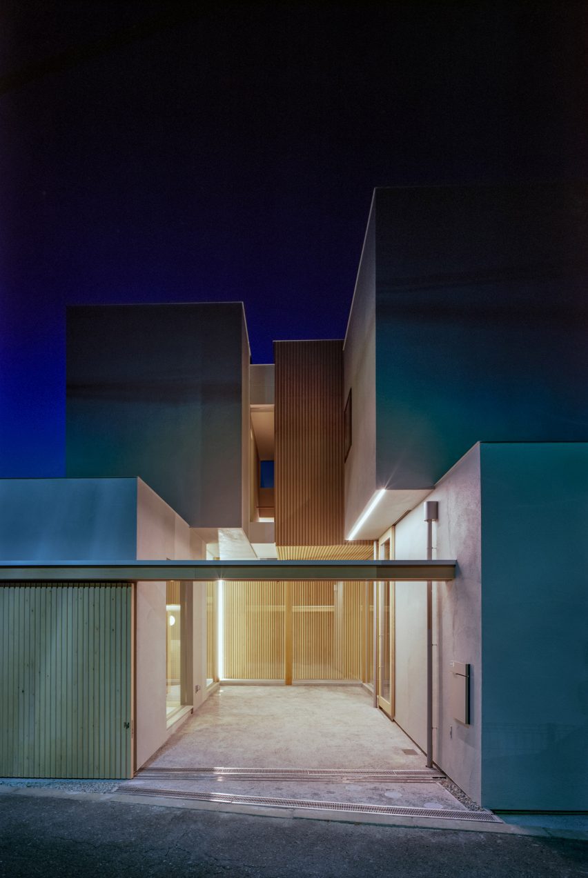 A square Japanese house lit up at night