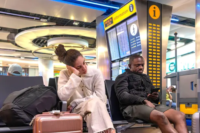 Male and female passengers waiting for a flight at Heathrow Airport departures (File image.)