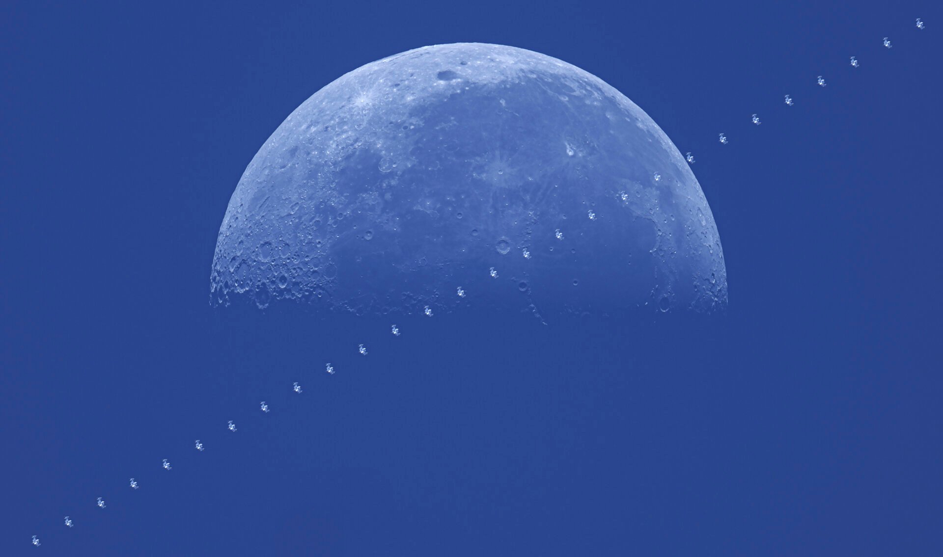 The International Space Station during the day over the moon