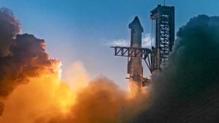 The top of the giant steel rocket just after launch next to its black launch tower.  The smoke glowed in orange waves below them, filling the frame on either side.