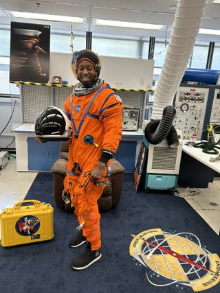 astronaut standing in space suit and smiling in office