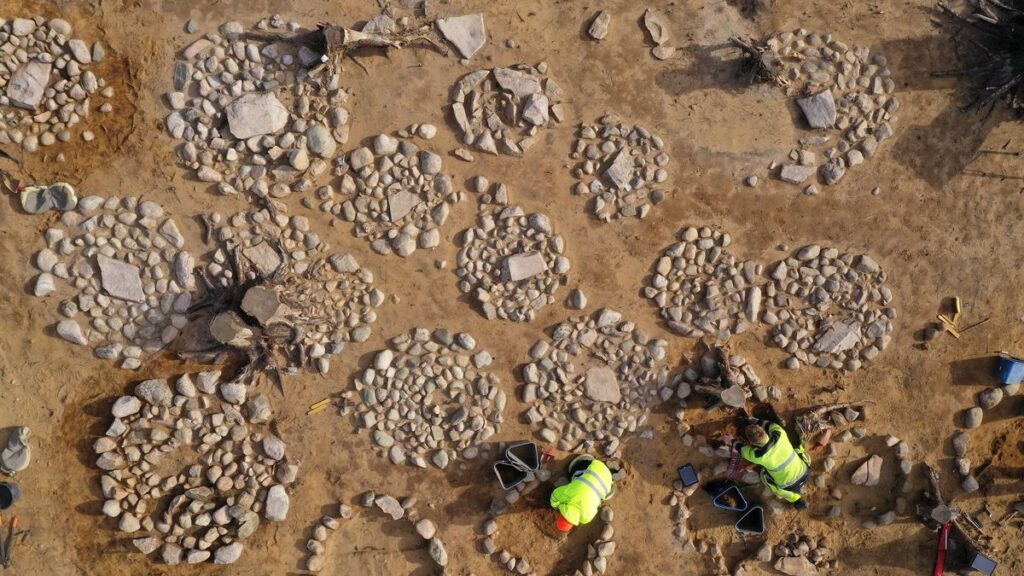 An aerial view showing many round, concentric circles of rocks marking the graves