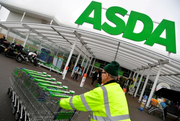 FILE PHOTO: A worker pushes shopping trolleys at an Asda store in west London, Britain, April 28, 2018. REUTERS/Toby Melville/File Photo