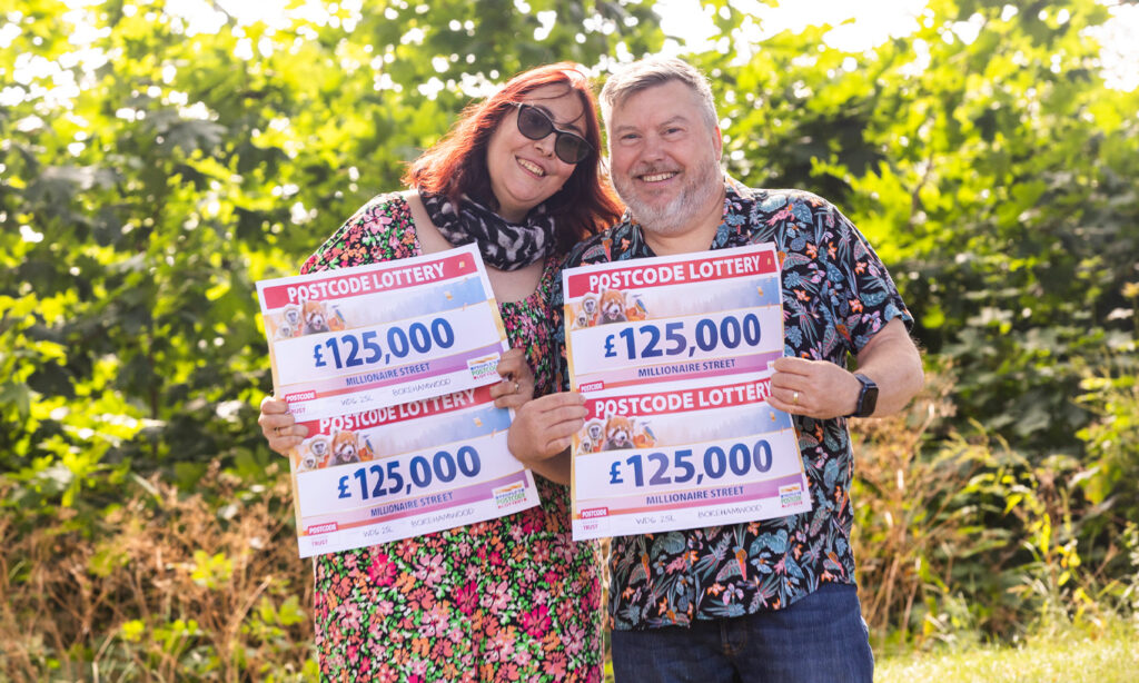 LIFE CHANGING: £500,000 winner Mark and wife Billie pose with their winning checks