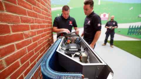 Engineers install a heat pump at the Octopus Energy training center