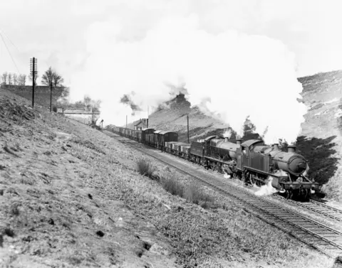 Getty Images Black and white photograph of a steam engine leaving the East End of the Severn in England