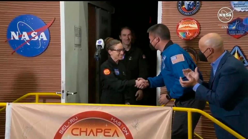 PHOTO: CHAPEA mission one crew members Kelly Haston shake hands with NASA Deputy Director of Flight Missions Kjell Lindgren as crew member Ross Brockwell exits their craft on July 6, 2024 at the Johnson Space Center in Houston, Texas.  (NASA via AP)